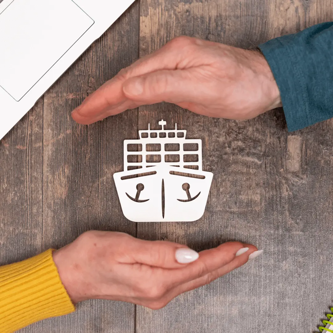 Two hands cradling paper cut out ship symbolising protection and insurance services for maritime assets