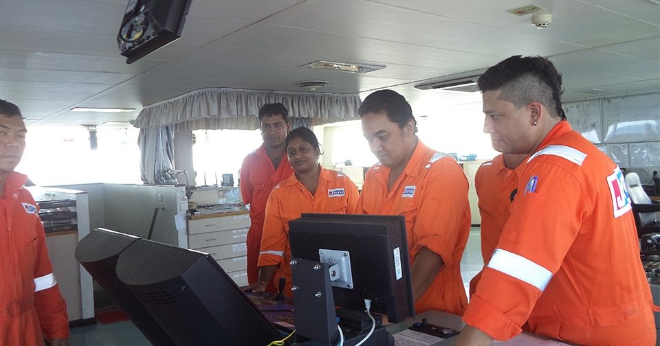 A woman engineer with her fellow seafarers on board a cargo ship
