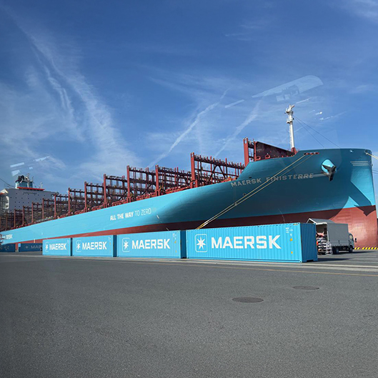 Exterior view of the Maersk Finisterre docked at a port, featuring the "All The Way To Zero" sustainability slogan on its hull.