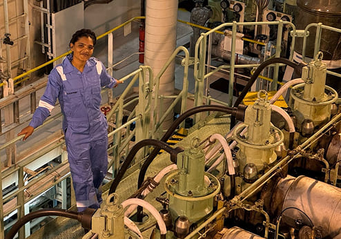 Engine Cadet Jaishni Jayakumar inspecting equipment in a ship engine room