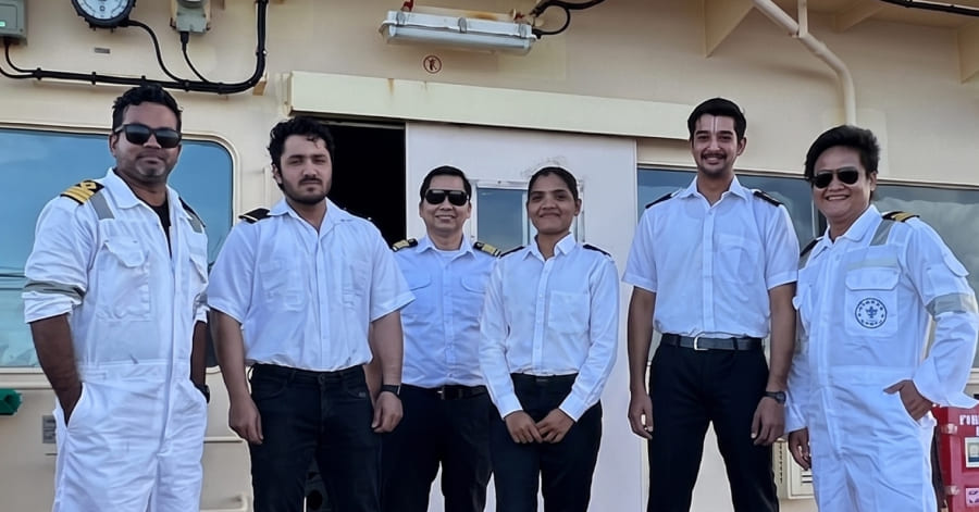 Engine Cadet Jaishni standing with group of maritime professionals standing on a ship deck